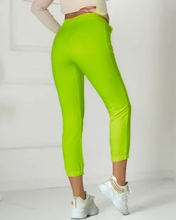 Neonowe żółte damskie spodnie dresowe z naszywką- Odzież