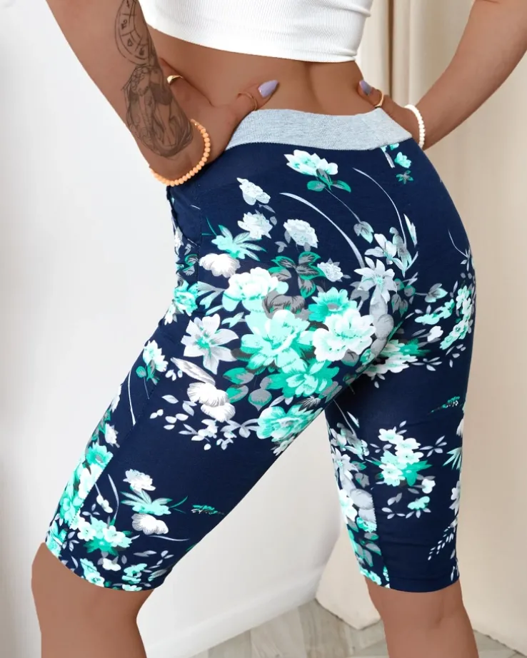 Royalfashion Granatowe spodenki damskie 3/4 w zielone kwiaty